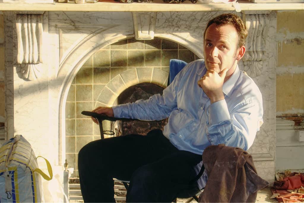 John Dyer Grimes sitting in front of period fireplace in Putney